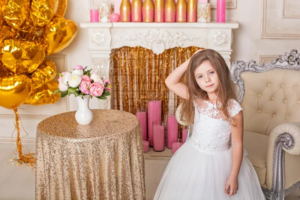 Little girl in a beautiful white dress in the interior. — Stock Photo, Image