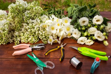 Garden tools, Tools for floristics and flowers on a wooden table. clipart
