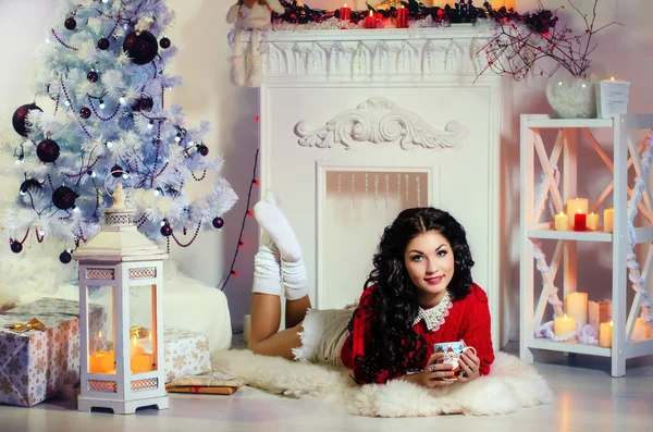 Chica de Navidad acostada en el suelo con una taza —  Fotos de Stock