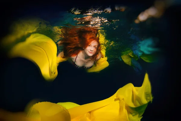 Menina elegante nova com cabelo vermelho posando na água . — Fotografia de Stock