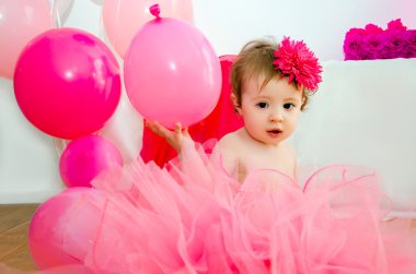 ilk doğum günü. Balonlar ve büyük bir basamak 1 ile kabarık pembe etek bebek