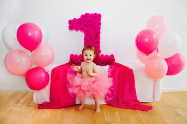 ilk doğum günü. Balonlar ve büyük bir basamak 1 ile kabarık pembe etek bebek
