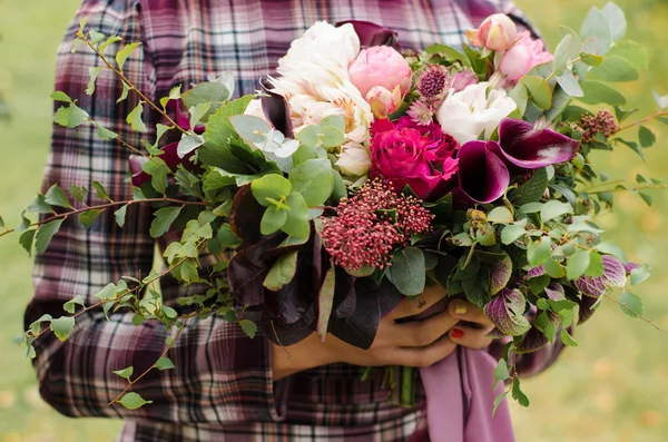 Bridal bouquet. Bride in a plaid dress holding a beautiful bouqu — Stock Photo, Image