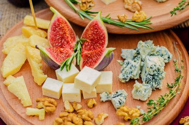 Peynir ve ahşap bir tepside fındık ile incir.