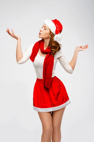 Christmas Santa hat isolated woman portrait . Looks aside on a gray background.Girl in white and red clothes — Stock Photo, Image