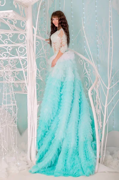 Fille dans une magnifique robe de mariée, la couleur de la menthe. Debout sur le bel escalier blanc décoratif . — Photo