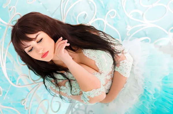 Portrait of a girl close-up in a wedding dress. Bride sitting on white stairs. — Stock Photo, Image