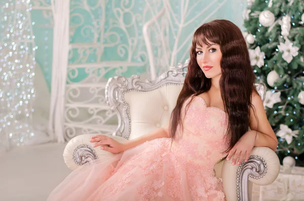 La fille dans une belle robe de mariée, assis dans une chaise de luxe dans la nouvelle année et décorations de Noël . — Photo