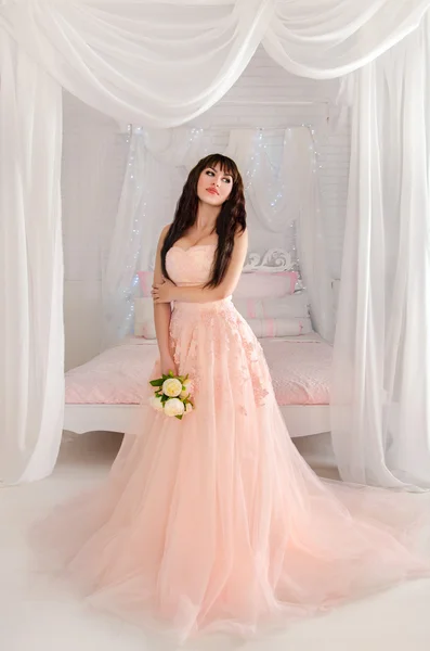 Casamentos Natal e Ano Novo.Bela noiva jovem em um vestido de pêssego. O quarto leve meigo. Casamento em rosa . — Fotografia de Stock