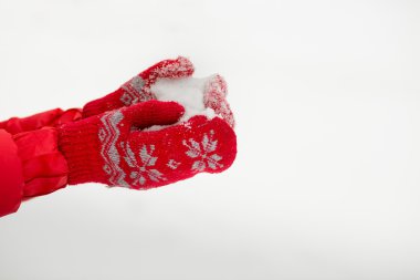 Kar ile kırmızı mittens kadın elinde.