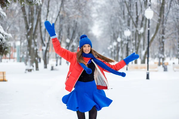 Hermoso invierno Retrato de una mujer joven en invierno paisaje cubierto de nieve. La chica se convierte en un baile divertido . — Foto de Stock