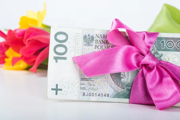 Şerit hediye üzerinde banknot yığını ile ilgili.