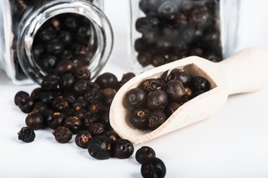 tahta kaşık ile kurutulmuş ardıç meyveleri