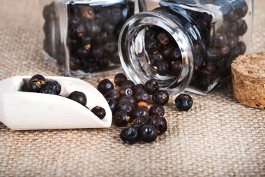 tahta kaşık ile kurutulmuş ardıç meyveleri