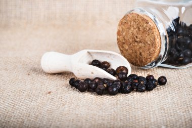 tahta kaşık ile kurutulmuş ardıç meyveleri