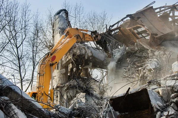 Escavatore che lavora alla demolizione di un vecchio edificio industriale . — Foto Stock