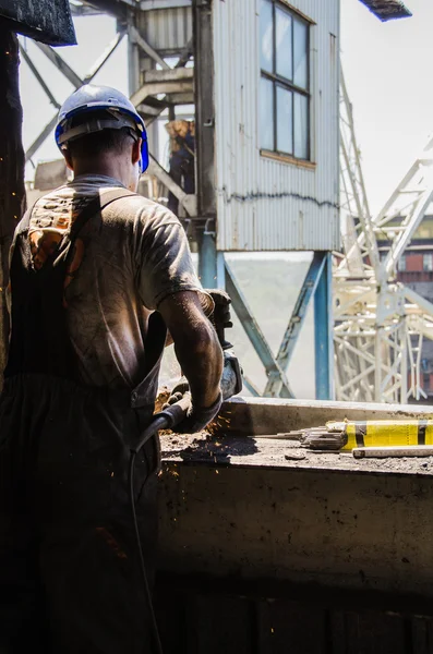 Worker grinding a metal plate. — Stock Photo, Image