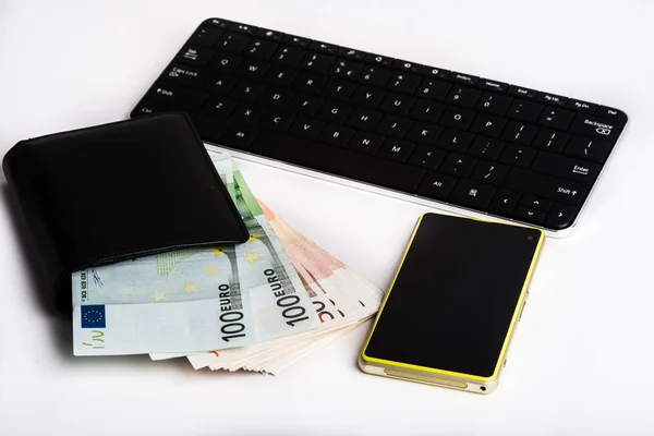 Billetera llena de euros, teclado y teléfono móvil . — Foto de Stock