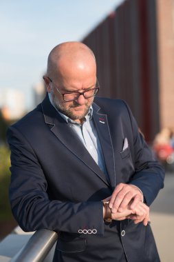 Toplantıdan önce saat takan adam.