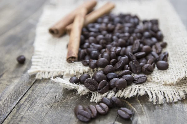 Coffee beans and cinamons on the wooden table — Stock Photo, Image