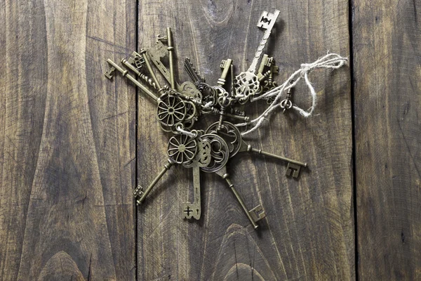 Staré klíče na dřevěný stůl — Stock fotografie
