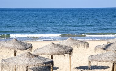 Chipiona saman şemsiyelerle Beach. 
