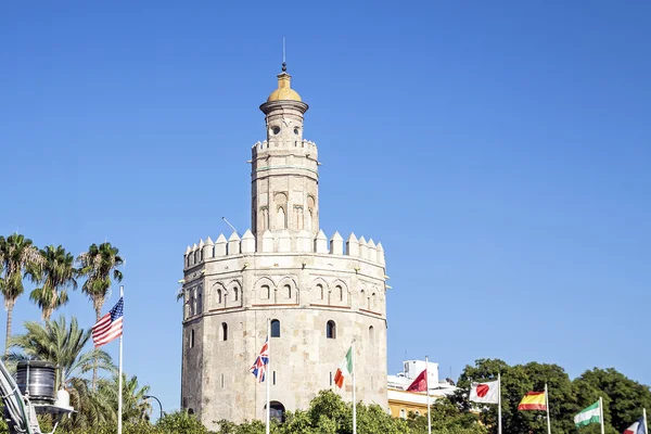 La Torre de Oro (Tower of Gold) with some flags. Seville, Andalu — Stock Photo, Image