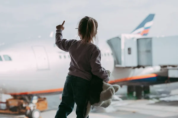 Kleinkind Flughafen Gesichtsmaske Mit Einem Spielzeug Kind Schaut Sich Flugzeug lizenzfreie Stockbilder