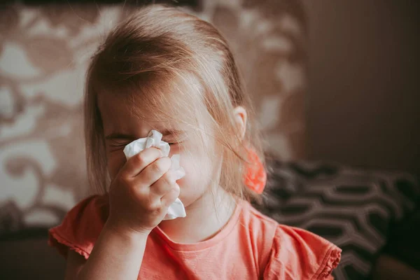 Hasta küçük kız burnunu silip gözleri kapalı mendille kaplıyor.