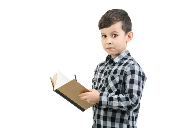 6岁的男孩穿着灰色衬衫在笔记本上写字 男孩对工作室的白色孤立背景感到惊讶 — 图库照片