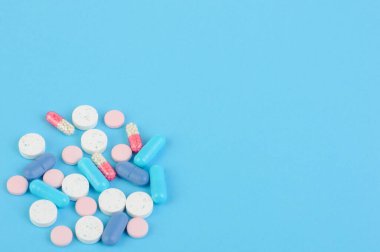 Mavi zemin üzerinde mavi ve beyaz haplar, COVID-19; Coronavirus; Tedavi; Virüs; Kopyalama Boşluğu