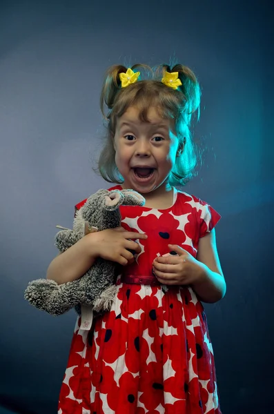 Pequeña niña artística con peluche de cerca en un fondo azul — Foto de Stock