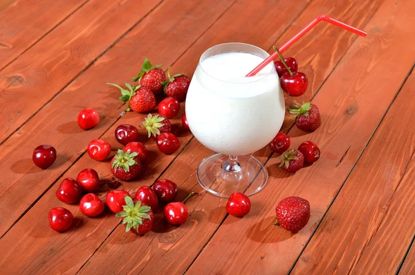 Cóctel de leche sobre mesa vieja de madera, bayas jugosas . — Foto de Stock