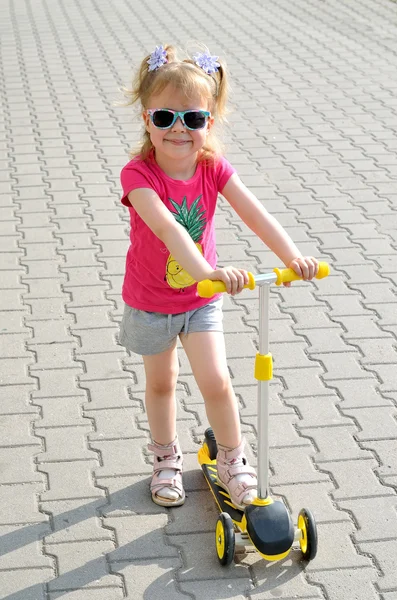 Piękna mała dziewczynka, w jeździe na hulajnodze, Zdjęcie z bliska. — Zdjęcie stockowe