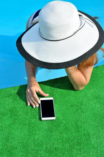 Mujer joven en la piscina con su teléfono inteligente, vista desde arriba . — Foto de Stock