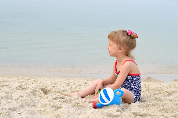 Vacker liten flicka som leker på stranden, utrymme för text. — Stockfoto