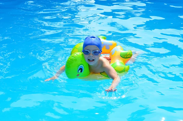 Niña feliz en una piscina en la gorra para nadar ingenio — Foto de Stock