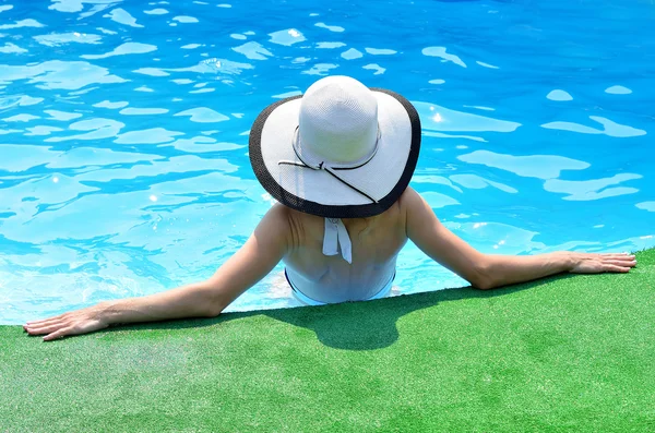 Hermosa mujer tomando el sol junto a la piscina, vista superior . — Foto de Stock