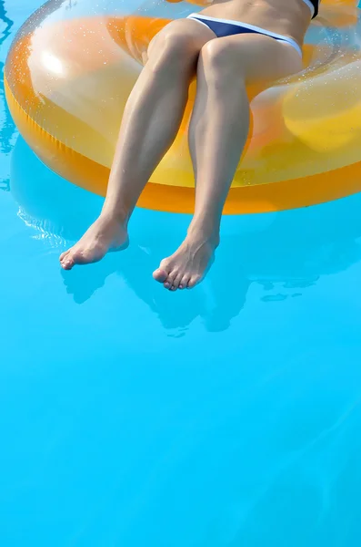 Sexy jeune femme flottant dans un cercle en caoutchouc, jambes rapprochées . — Photo