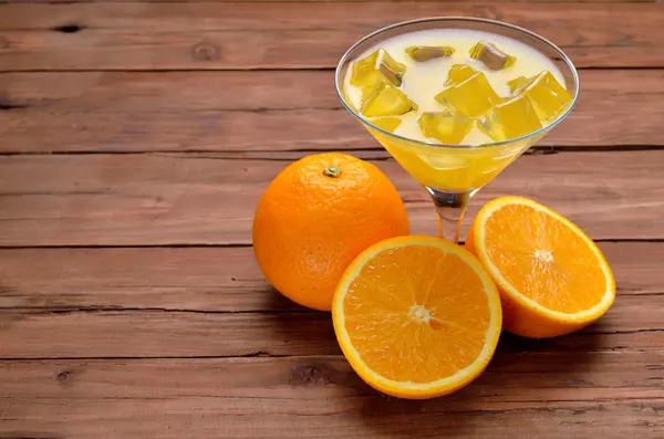 Стакан свіжого апельсинового соку та апельсина на старому дерев'яному столі . — стокове фото
