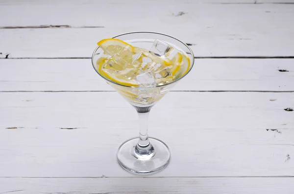 Martini s citronu ve sklenici na bílém stole. — Stock fotografie
