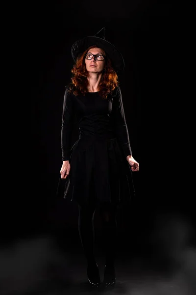 Siyah Elbiseli Genç Bir Kadın Siyah Arka Planda Cadı Şapkası — Stok fotoğraf