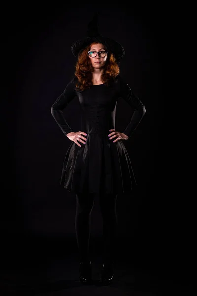 Siyah Elbiseli Genç Bir Kadın Siyah Arka Planda Cadı Şapkası — Stok fotoğraf