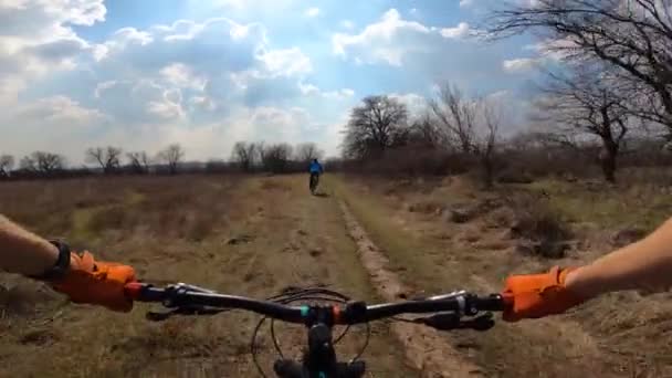 Dois ciclistas estão a percorrer o trilho através do campo. Da primeira pessoa. — Vídeo de Stock