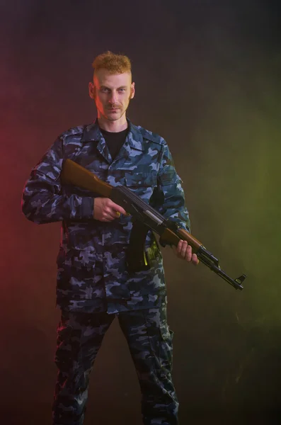 Man in camouflage clothing with a gun — Stock Photo, Image