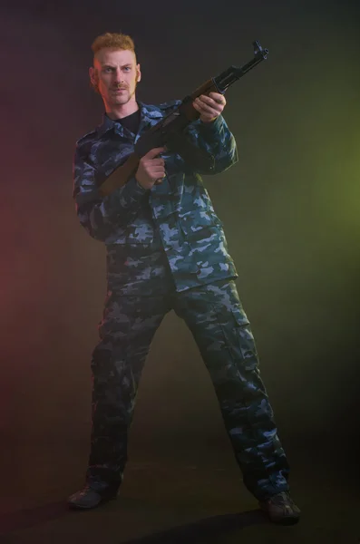 Man in camouflage clothing with a gun — Stock Photo, Image