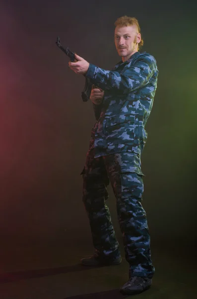 Man in camouflage clothing with a gun — Stock Photo, Image