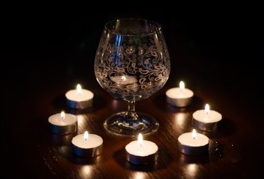 Şarap kadehi ve yanan mumlar