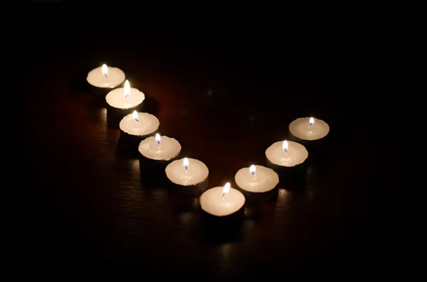 Anordnung brennender Kerzen auf schwarzem Hintergrund — Stockfoto