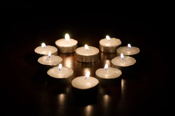 Velas ardientes en forma de corazón sobre fondo negro —  Fotos de Stock